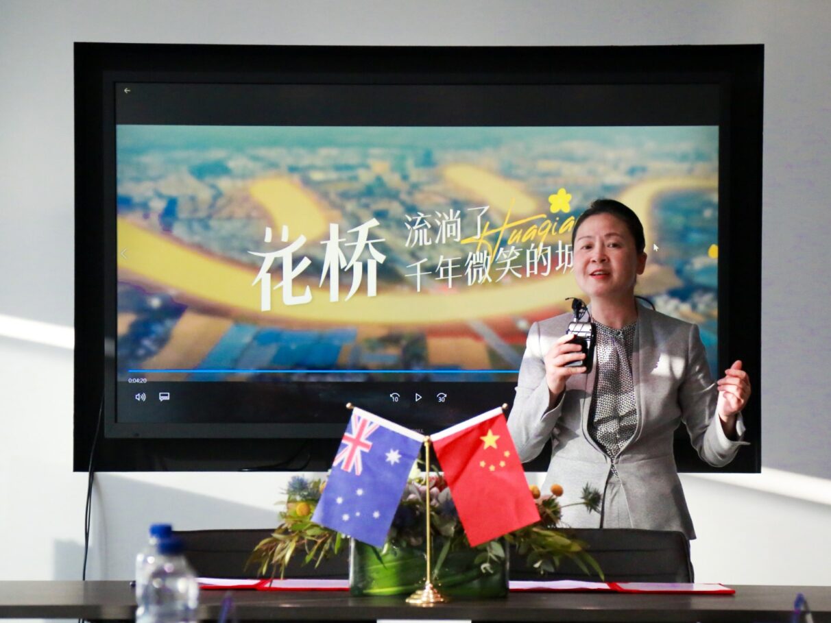 A person standing in front of a screenDescription automatically generated